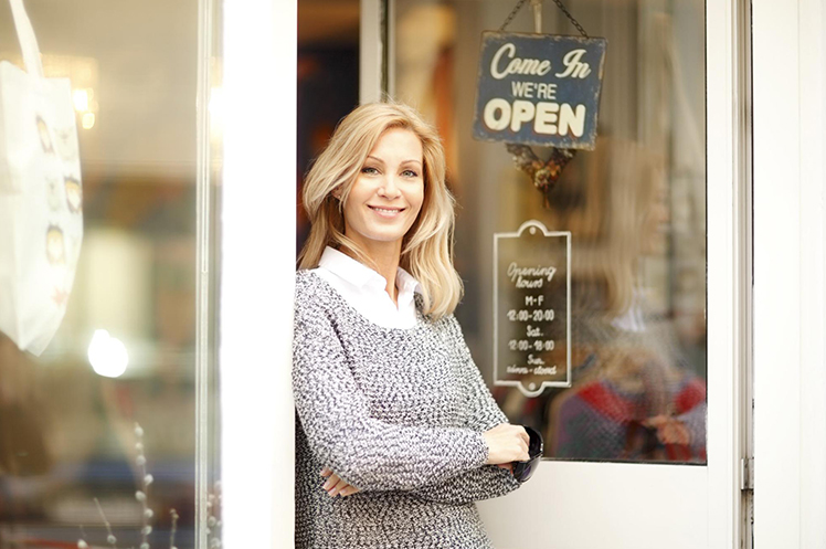 Business owner standing in front of her shop