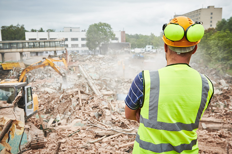 Demolition contractor looking at accomplished demolition work