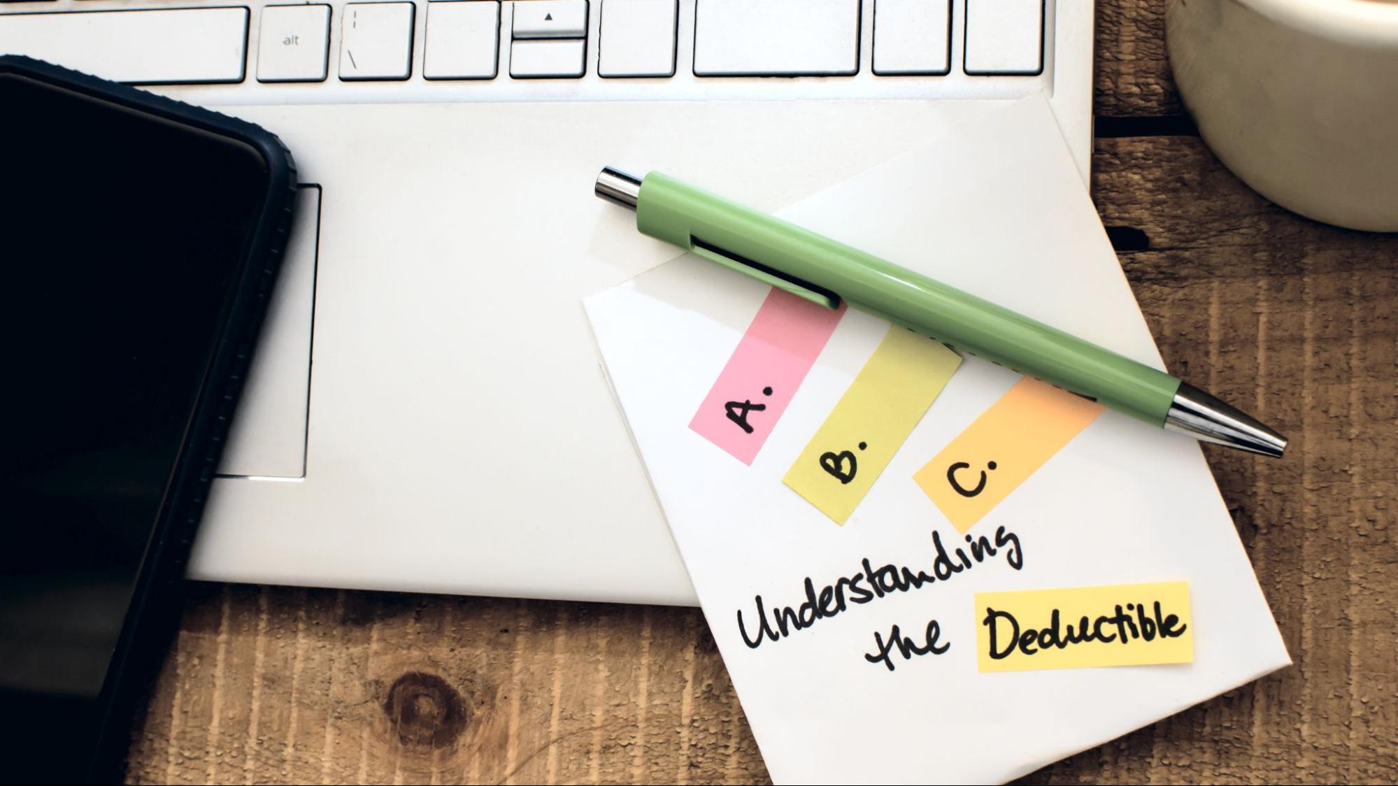 Close-up of a note on a laptop saying “Understanding the Deductible”