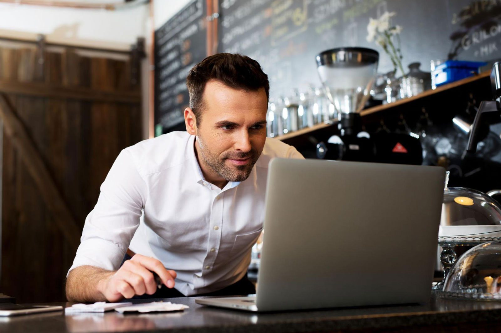 A new restaurant owner intently looking at his laptop