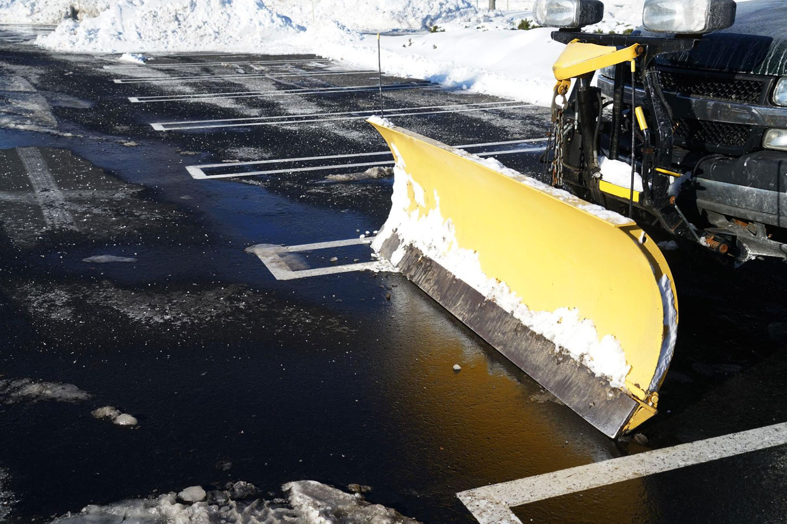 A snowplow clearing away snow from a parking lot