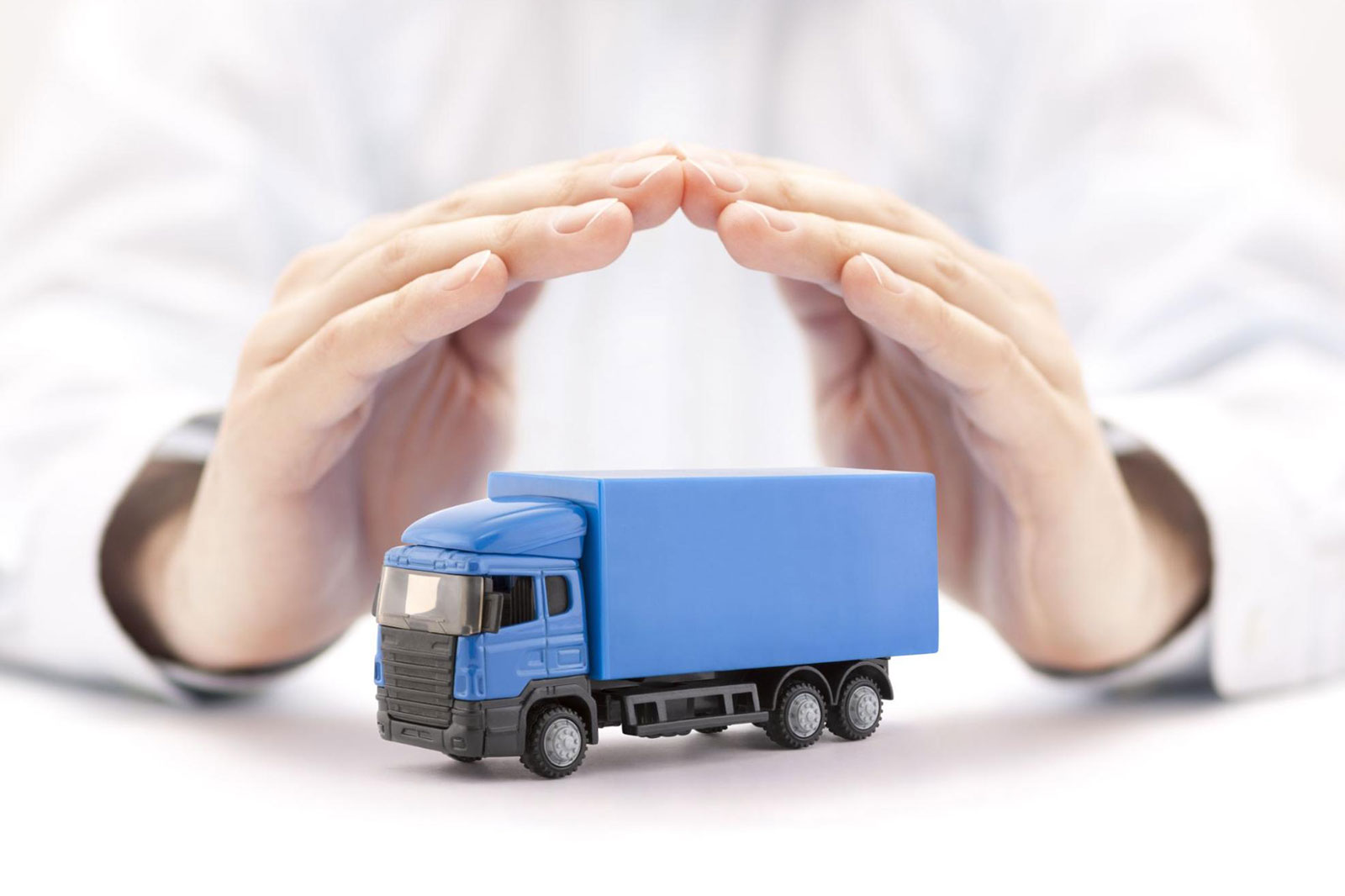 Hands arched over a truck, representing trucking insurance