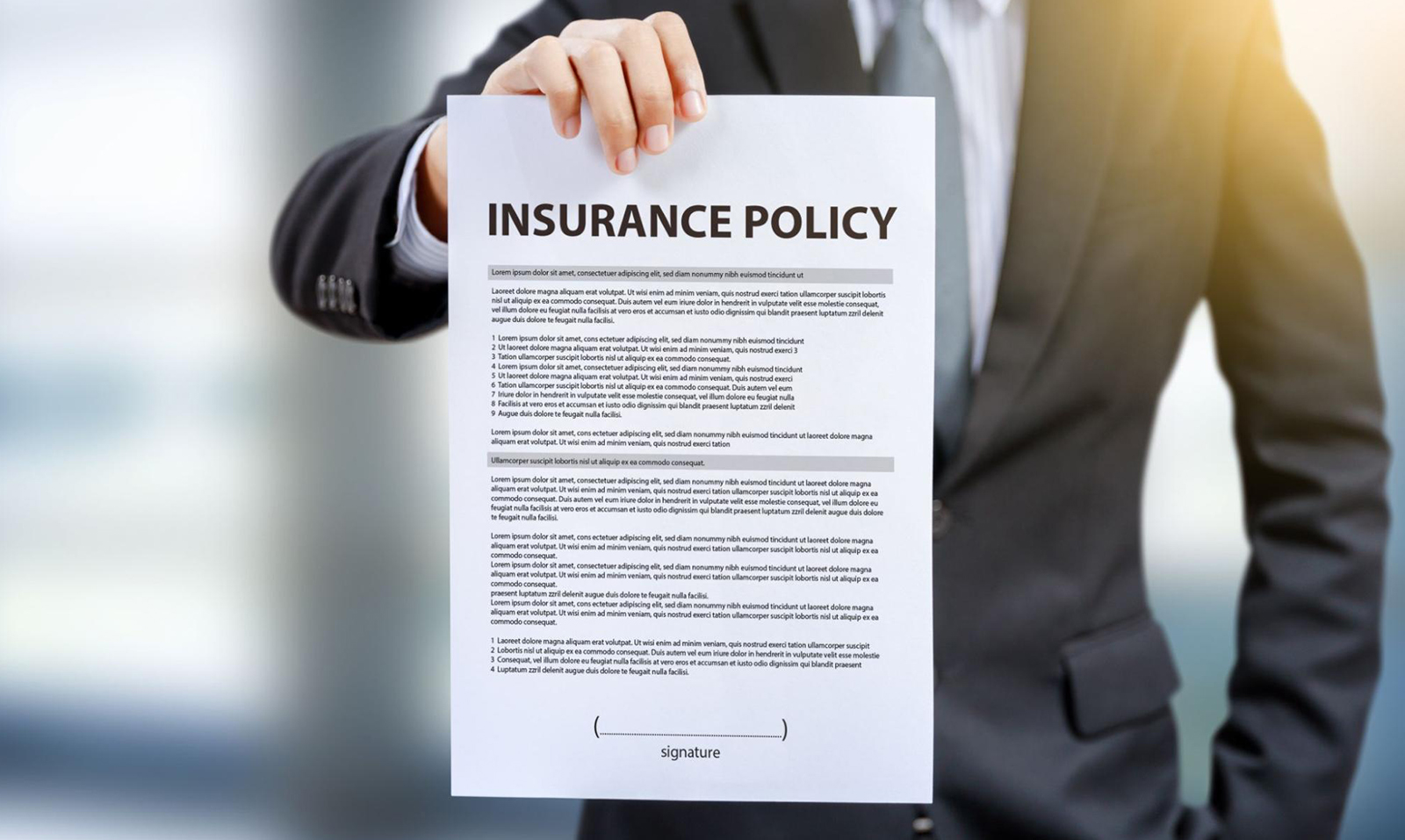 A man holding up an insurance policy that contains an insurance warranty clause