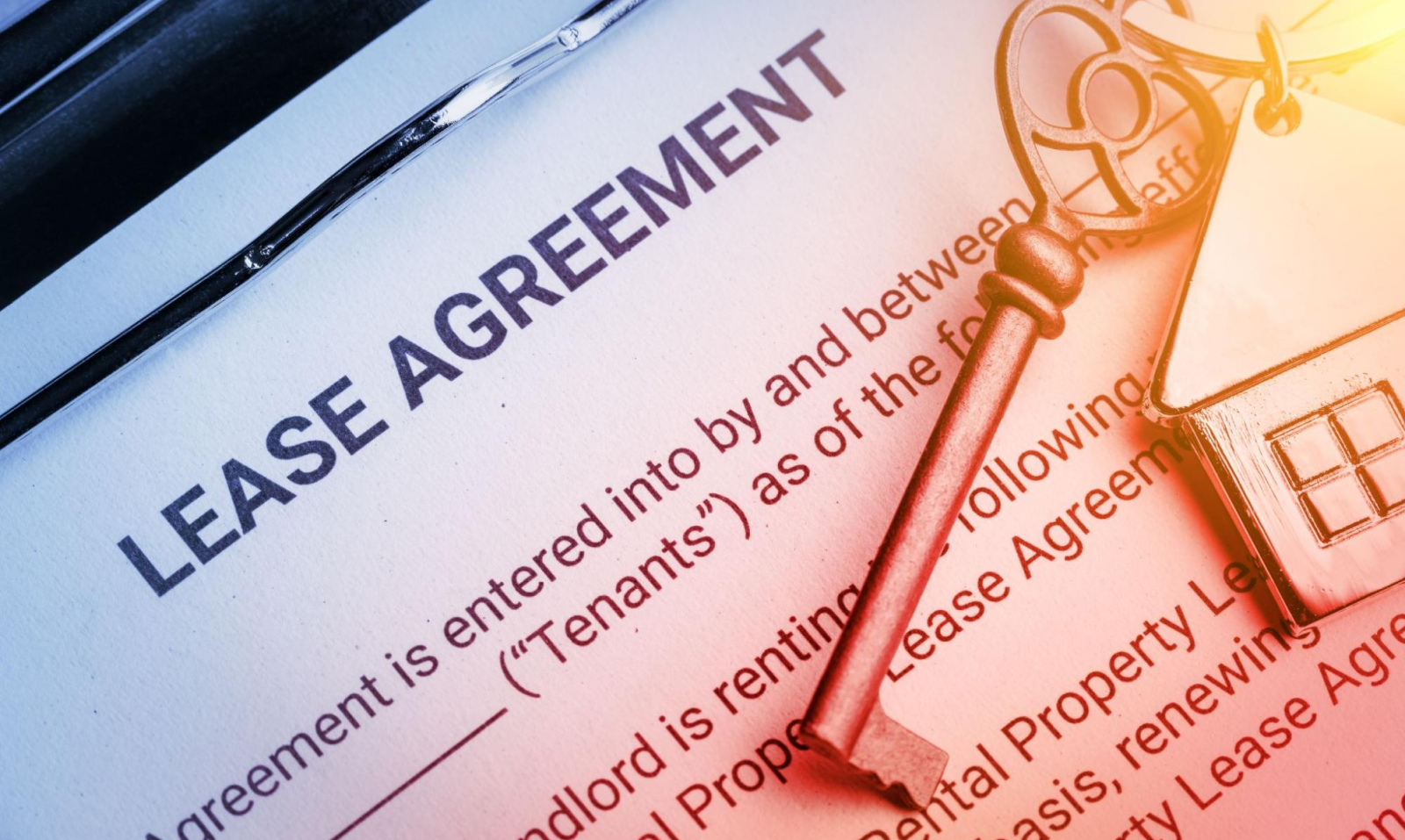 Close-up of lease agreement papers and a key to a rental property