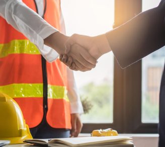An insurance broker shakes hands with a contractor
