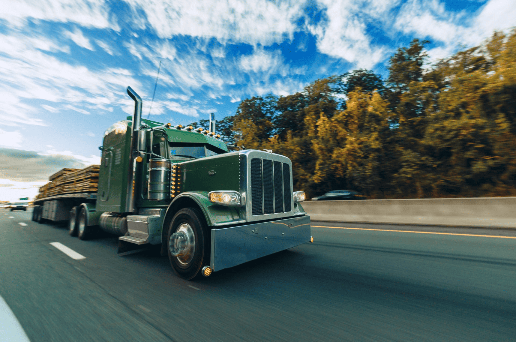 A truck driving fast on a highway.