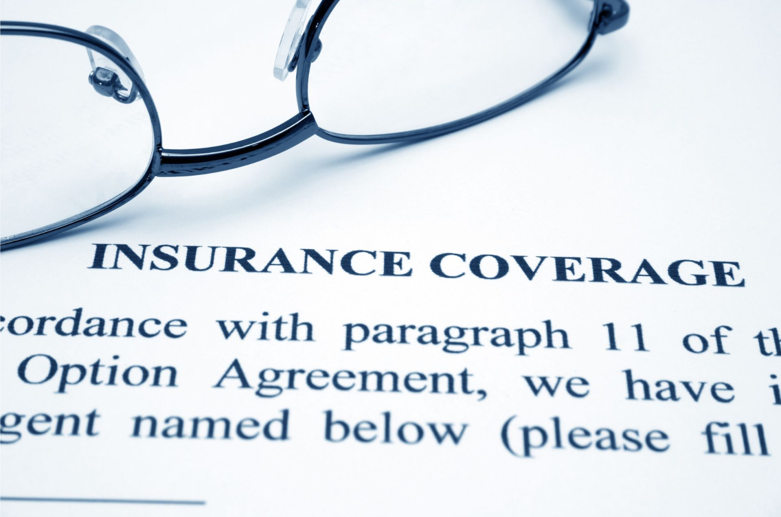 The words “insurance coverage” printed in bold on a page below a pair of glasses