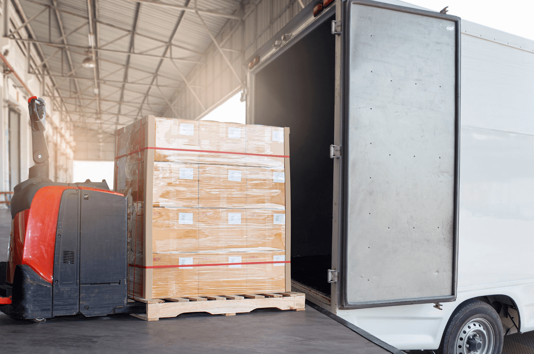 A heavy-haul loader transferring goods into a truck. 