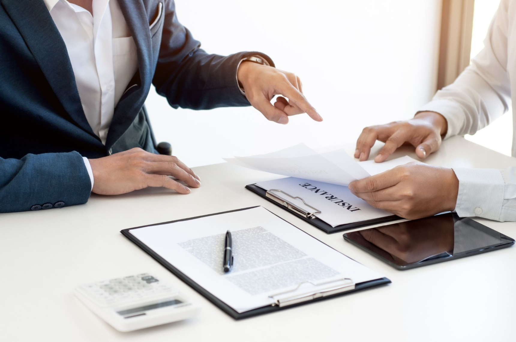 Two people discussing an insurance plan that’s been printed on paper 