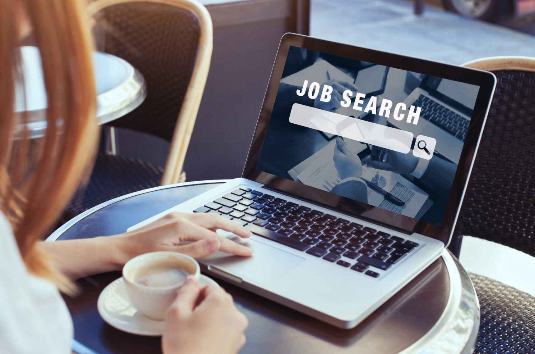 Someone scrolling on a job search website while holding a coffee
