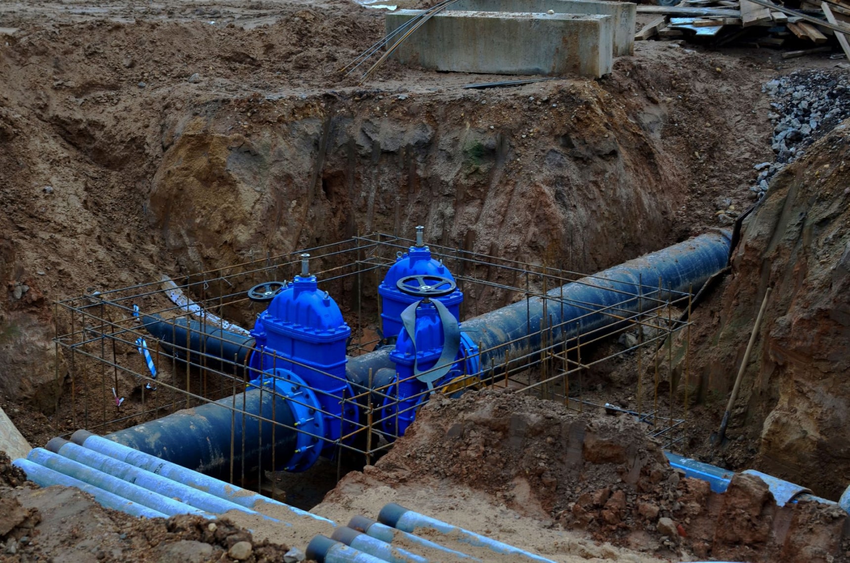  Exposed watermains in a dirt pit that are part of a system under construction 
