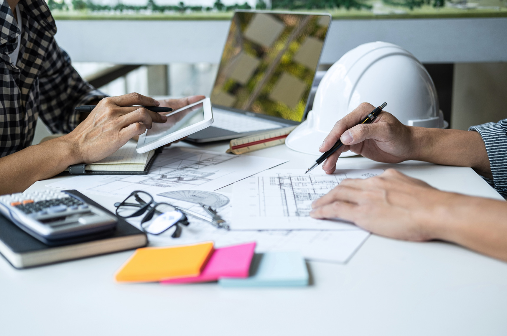 Contractor talking to an insurance broker, sticky notes and papers on the desk
