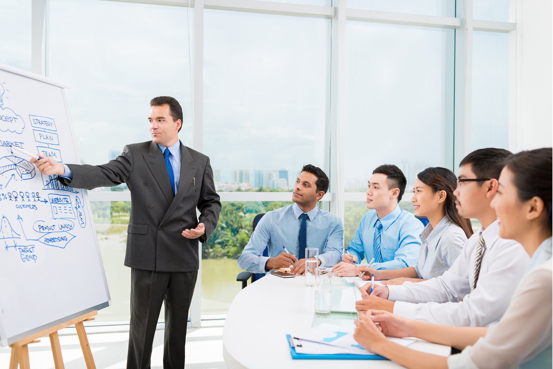 A team leader in a suit leading a meeting on risk management strategies