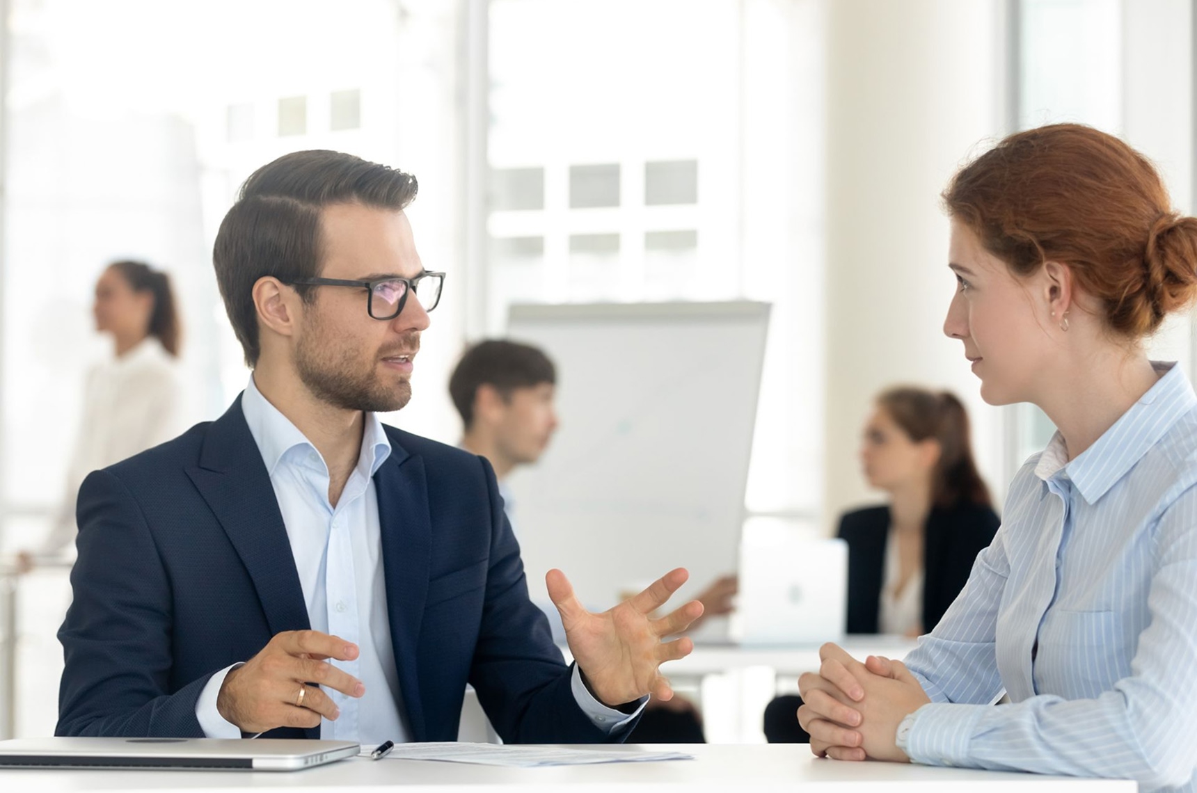 Benefits broker sitting at table with employer discussing benefits options
