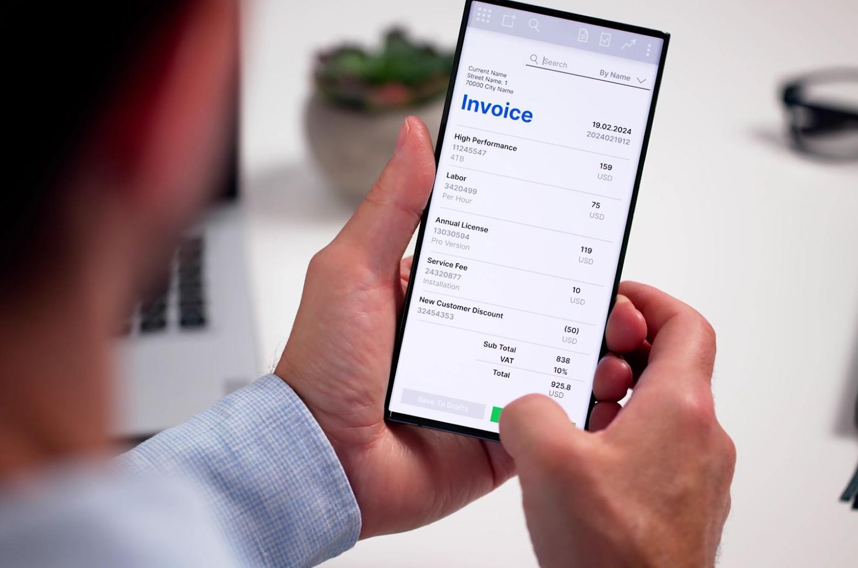 Man holding phone and issuing an invoice to a client