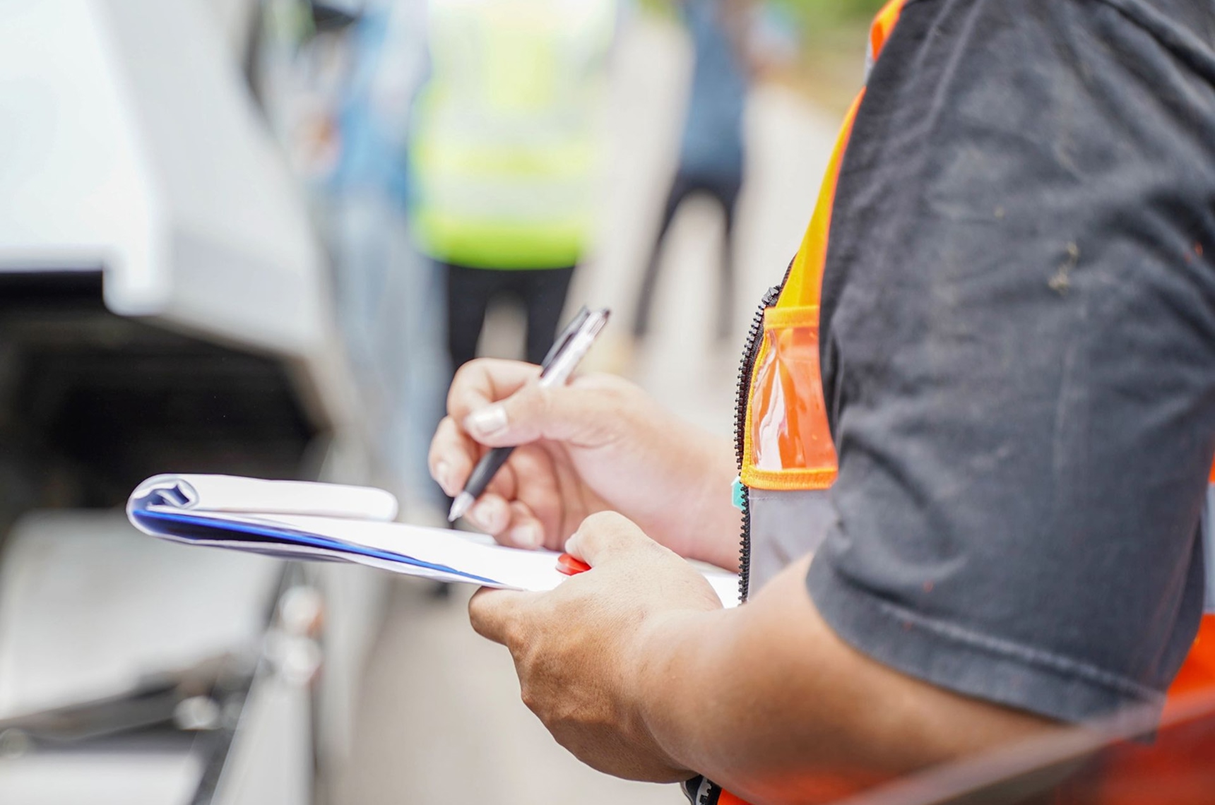 Contractors standing with a clipboard reviewing their surety bond requirements