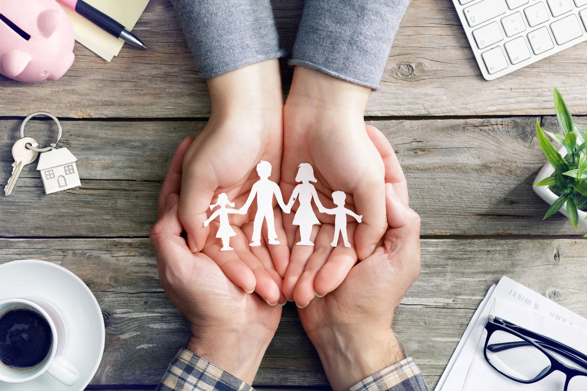 A couple holding a cut-out paper figure of a family