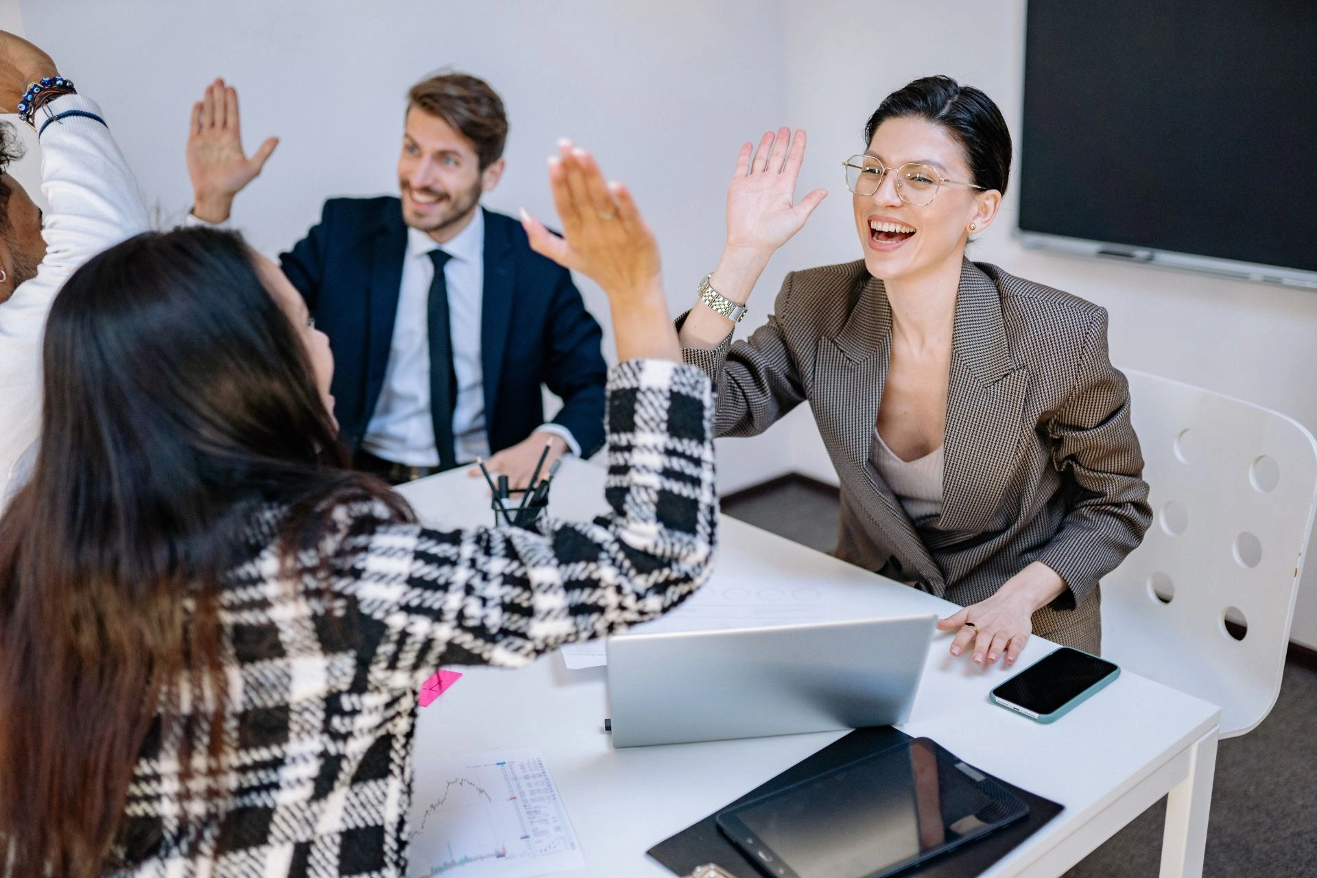 Employees high-five each other in a meeting
