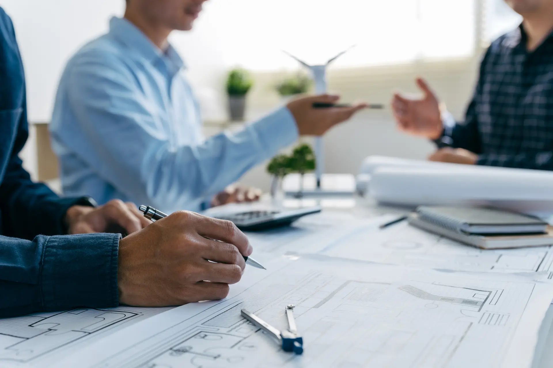 architects, engineers, and contractors working in an office with blueprints

