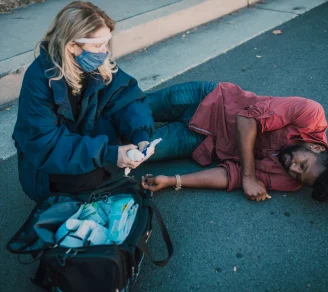 A paramedic helping an injured person on the floor