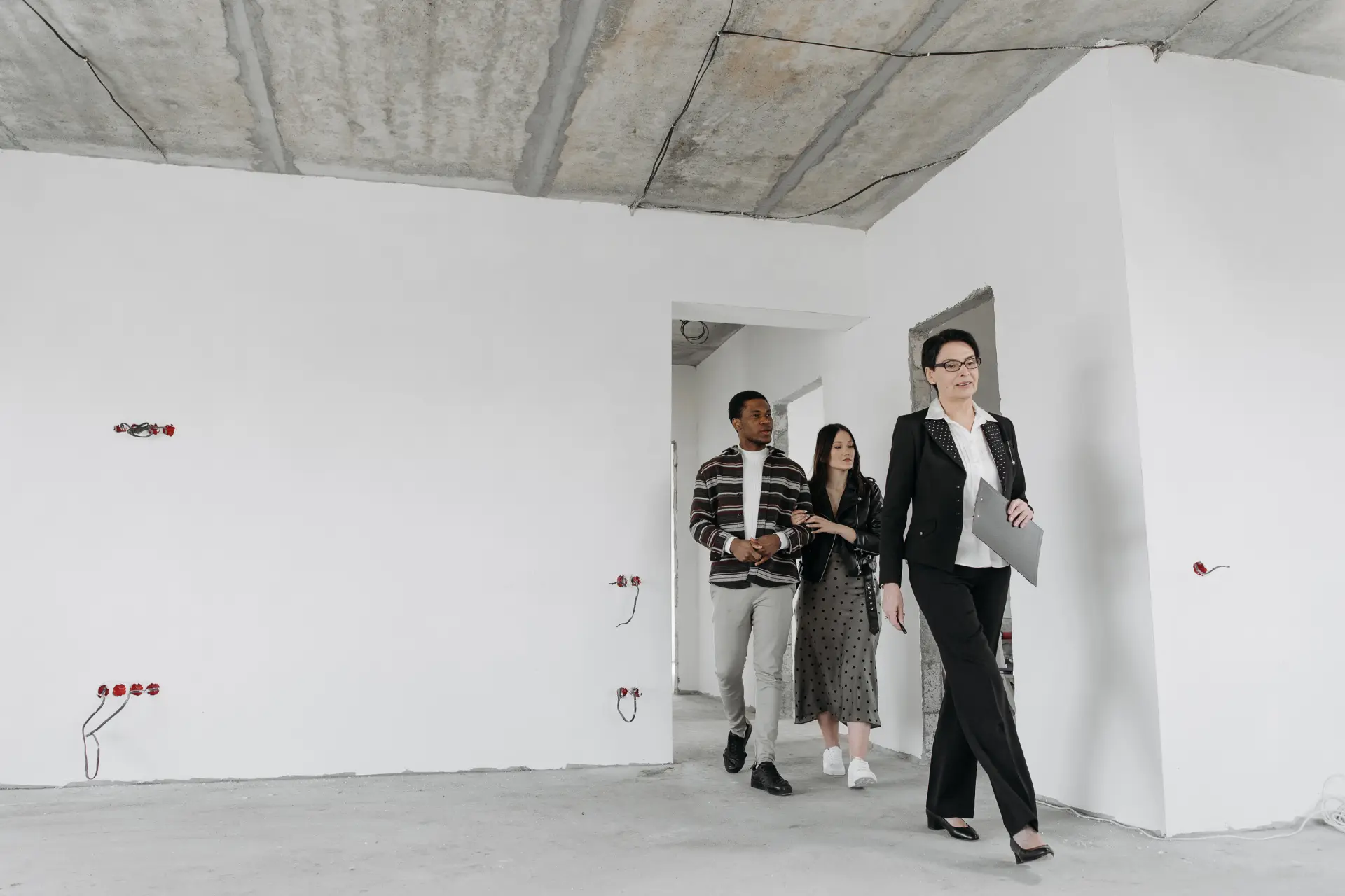 A couple viewing an empty commercial space with a real estate agent
