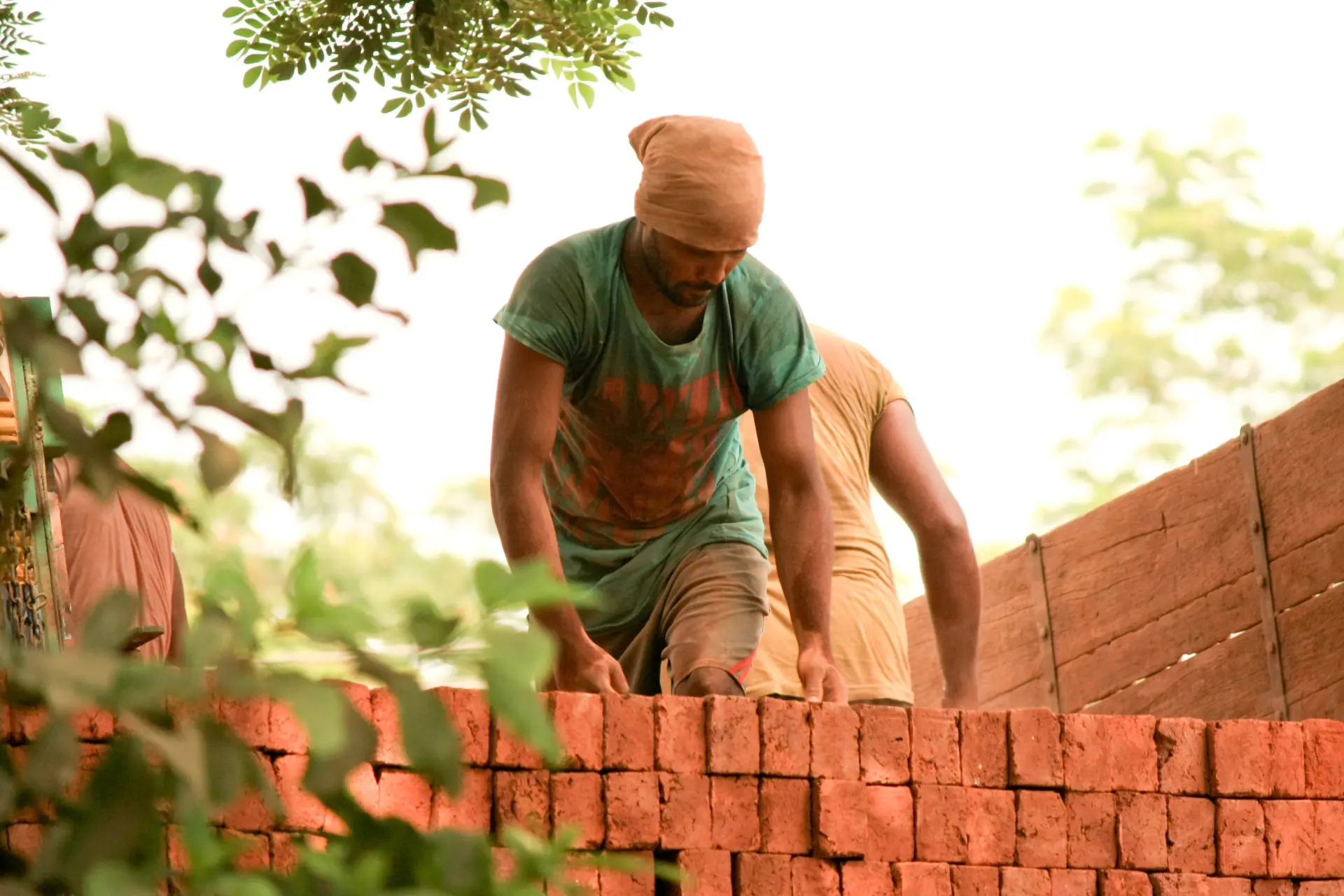 A landscape contractor laying bricks during a project
