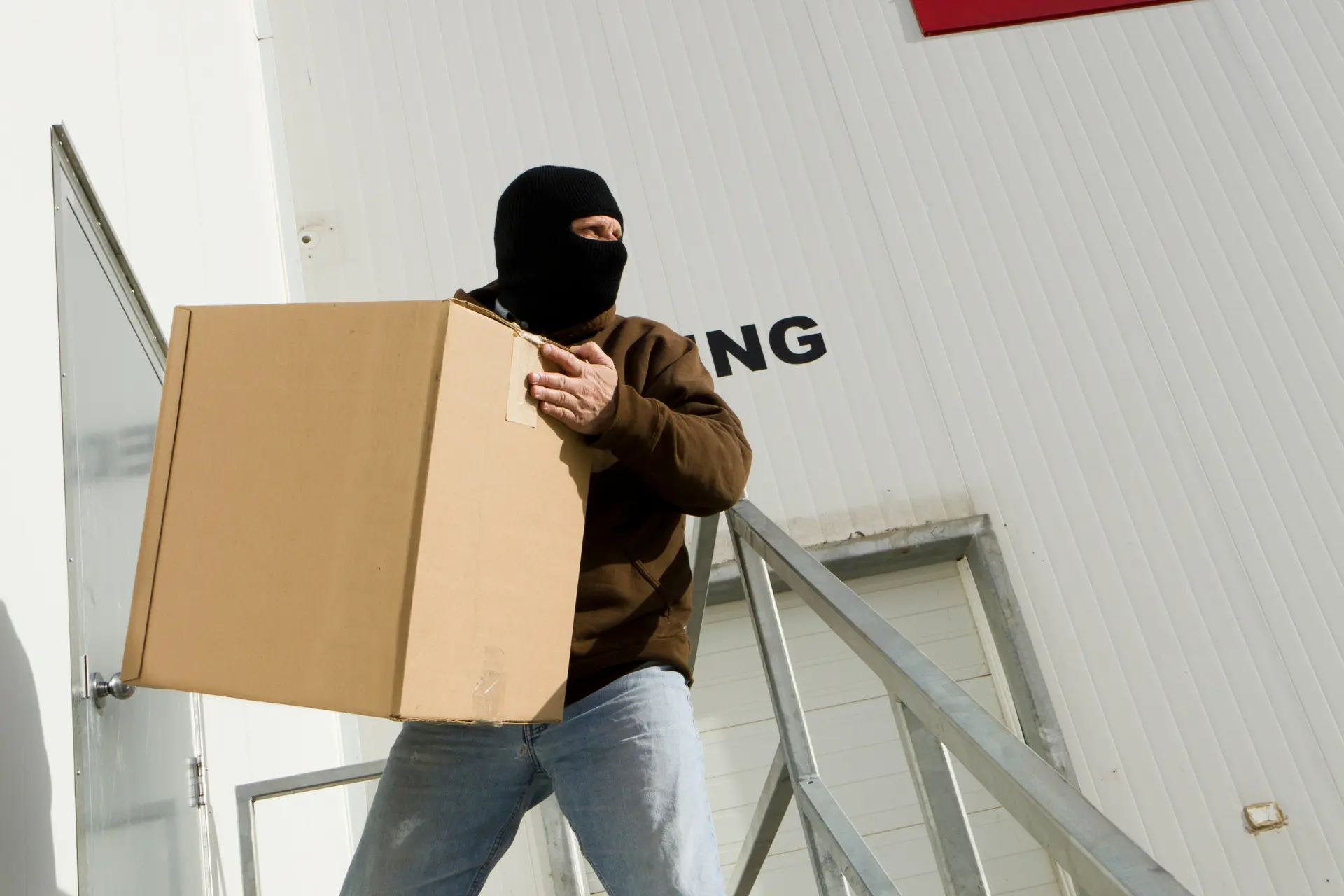 A thief stealing a box from a warehouse