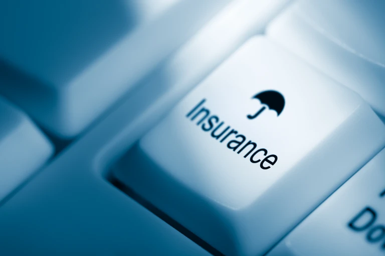 Close-up of a keyboard key labelled “Insurance” with a small umbrella icon, symbolizing umbrella insurance protection
