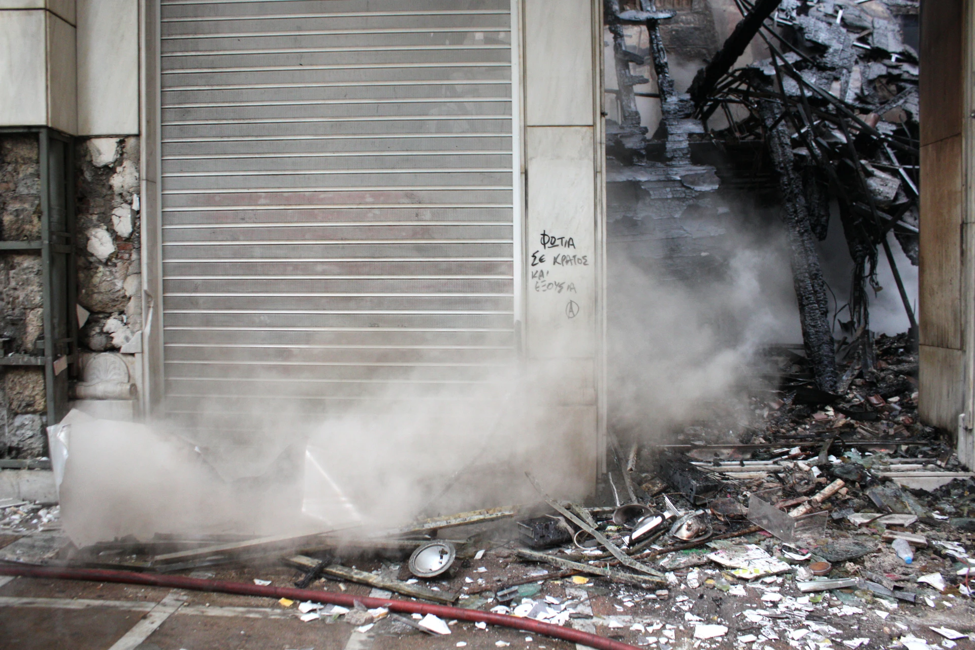 Business closed due to riots and civil unrest; surrounded by smoke and rubble
