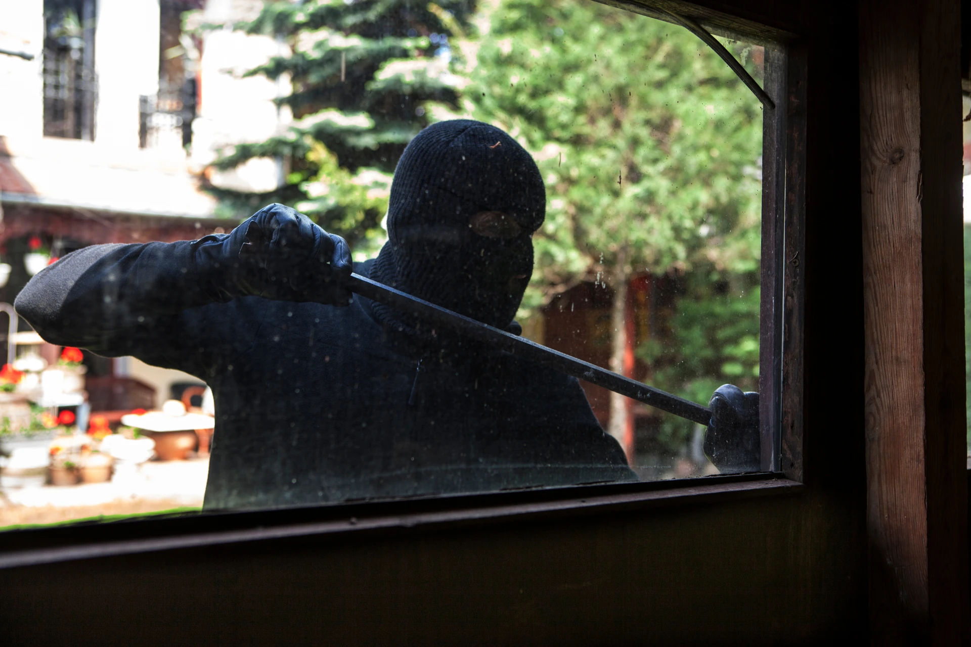 A burglar trying to open a window
