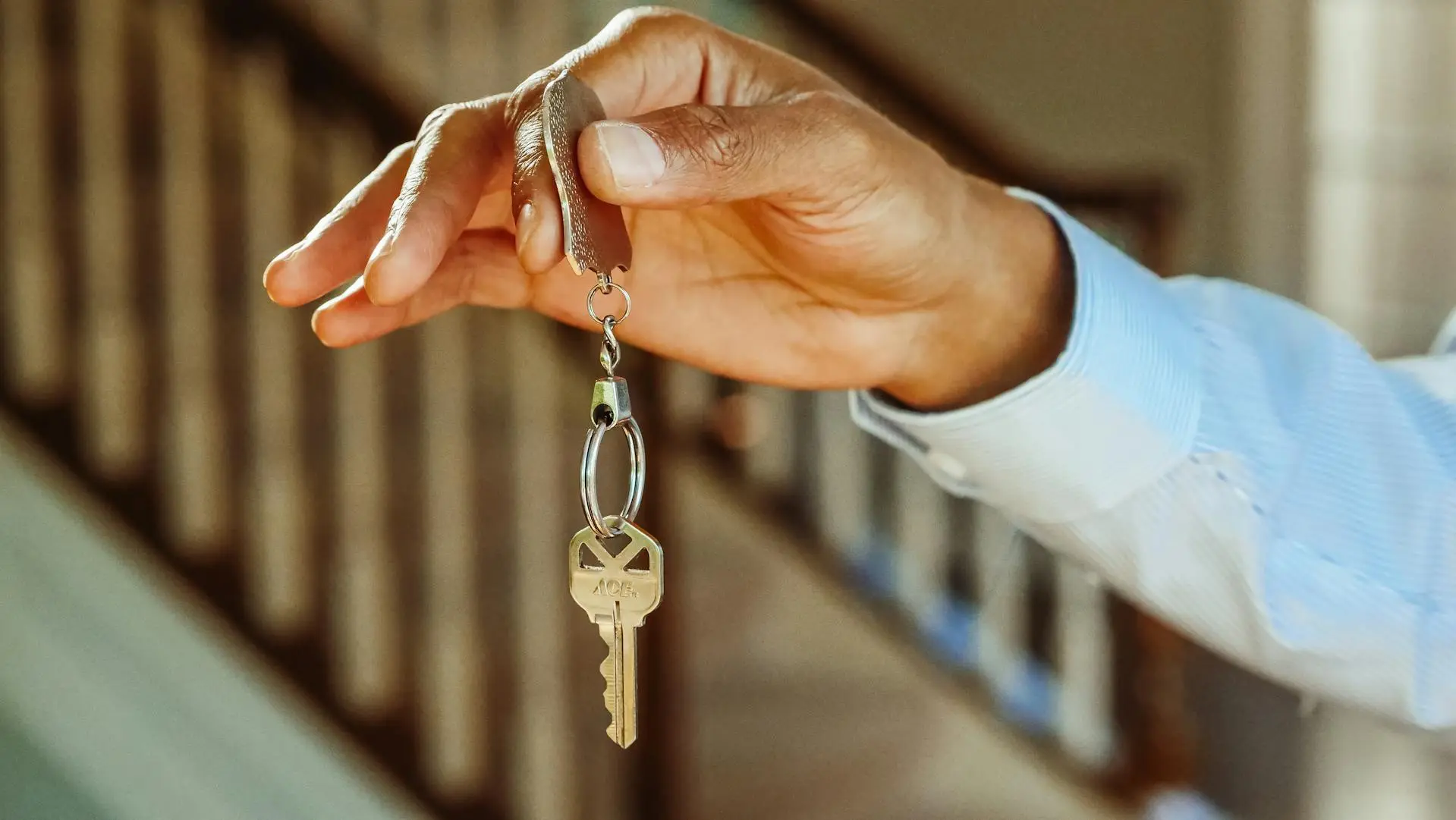 A hand holding the keys to a house
