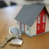 A miniature house beside a silver key